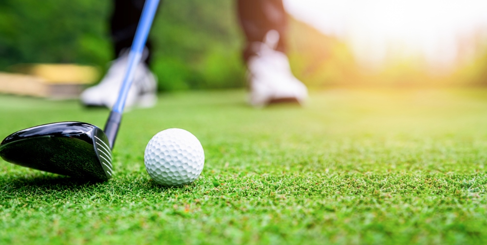 Close up golf ball on green grass field. sport golf club